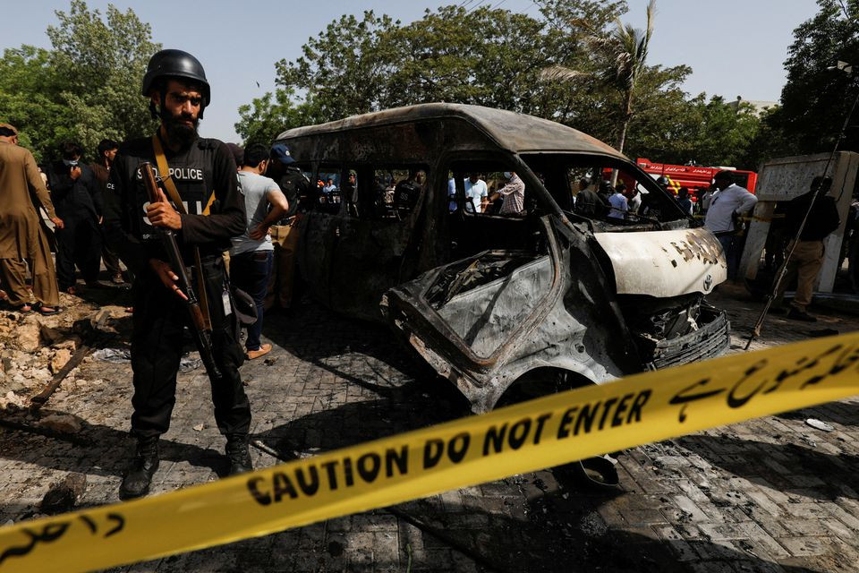 a police officer stands guard near a passenger van cordoned after a blast at the entrance of the confucius institute university of karachi pakistan april 26 2022 photo reuters