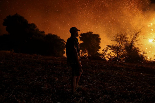 a man is silhouetted as he watches a wildfire burning in the village of lasdikas near ancient olympia greece august 5 2021 photo reuters a man is silhouetted as he watches a wildfire burning in the village of lasdikas near ancient olympia greece august 5 2021 photo reuters