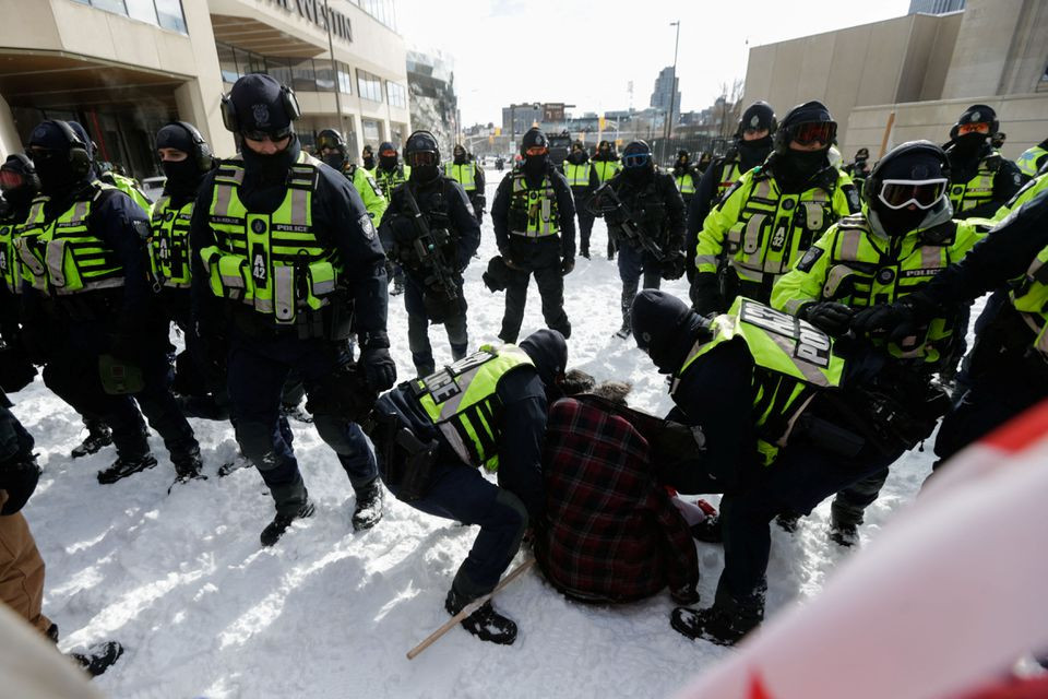 police officers detain a man as truckers and supporters continue to protest coronavirus disease covid 19 vaccine mandates in ottawa ontario canada february 18 2022 reuters