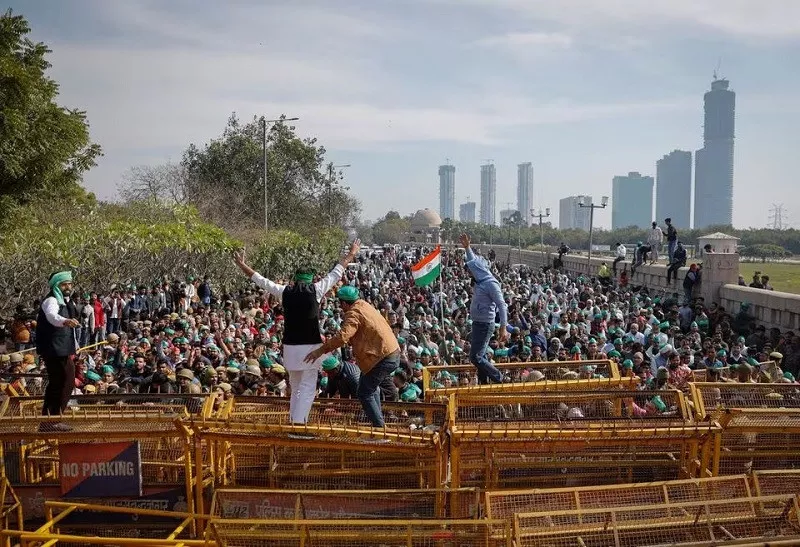 farmers climb a police barricade during a protest in noida on the outskirts of new delhi india february 8 2024 photo reuters farmers climb a police barricade during a protest in noida on the outskirts of new delhi india february 8 2024 photo reuters