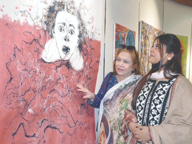 women take an interest in a work of art as they try to fathom the message in the scream of the figure on display at the hyderabad literature festival photo ppi