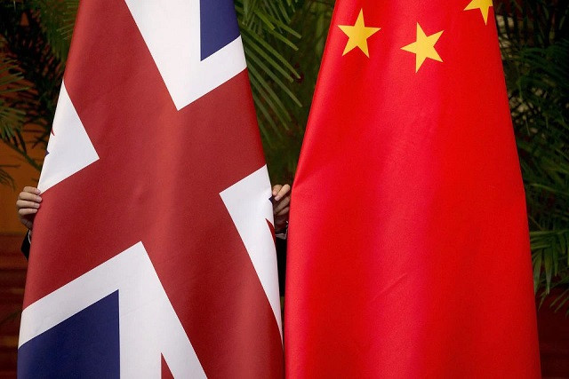 a worker adjusts british and china r national flags on display for a signing ceremony at the seventh uk china economic and financial dialogue roundtable on public private partnerships at diaoyutai state guesthouse in beijing china september 21 2015 photo reuters