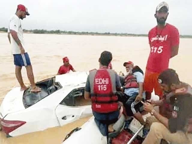 edhi rescue officials pictured while recovering a damaged vehicle that got swept away in a flash flood near kathore in karachi photo express edhi rescue officials pictured while recovering a damaged vehicle that got swept away in a flash flood near kathore in karachi photo express