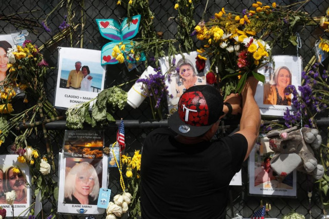 a man places flowers on a makeshift memorial for the victims of the surfside s champlain towers south condominium collapse in miami florida u s july 8 2021 photo reuters a man places flowers on a makeshift memorial for the victims of the surfside s champlain towers south condominium collapse in miami florida u s july 8 2021 photo reuters