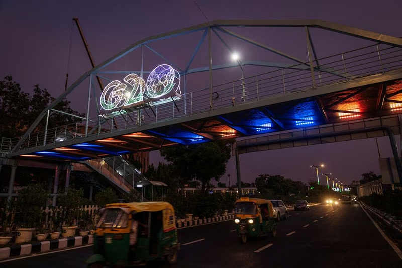 traffic moves past under a g20 logo installed on a pedestrian bridge in front of the main venue of the summit in new delhi india august 24 2023 photo reuters