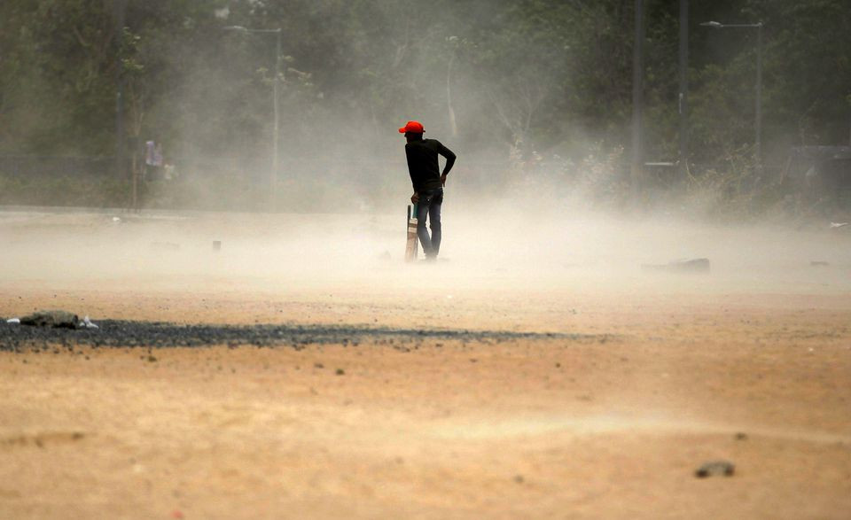 a boy waits for a brief dust storm to pass while playing cricket on a hot day in ahmedabad india april 17 2016 photo reuters