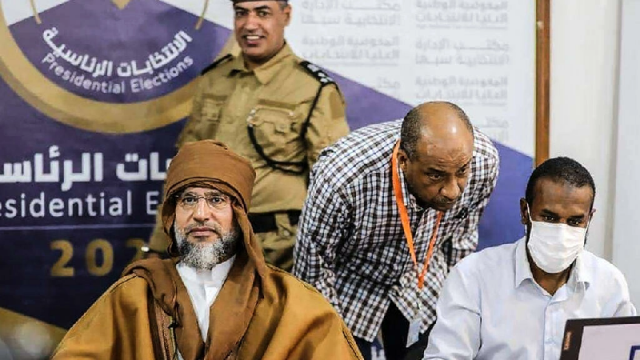 a handout picture released by the the libyan high national commission facebook page on november 14 2021 shows seif al islam kadhafi l registering to run in the country s december presidential polls in libya s southern city of sebha photo afp a handout picture released by the the libyan high national commission facebook page on november 14 2021 shows seif al islam kadhafi l registering to run in the country s december presidential polls in libya s southern city of sebha photo afp