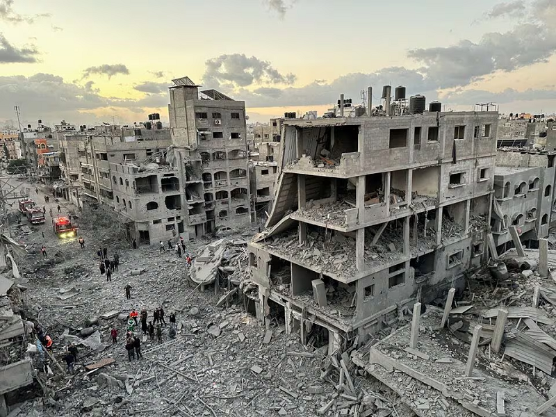 Palestinians walk at the site of Israeli strikes on houses, in Jabalia refugee camp in the northern Gaza Strip November, 21, 2023. PHOTO: REUTERS