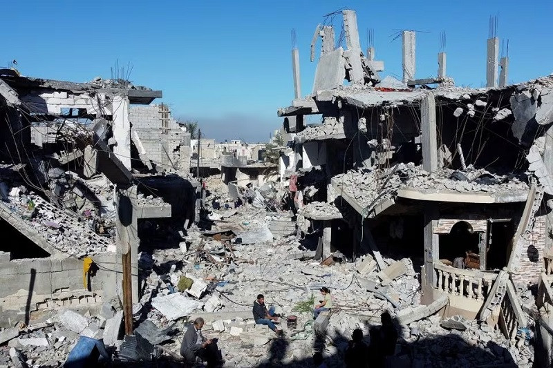 Palestinians cook among the houses destroyed in Israeli strikes at Khan Younis refugee camp, in the southern Gaza Strip, November 29, 2023. PHOTO: REUTERS