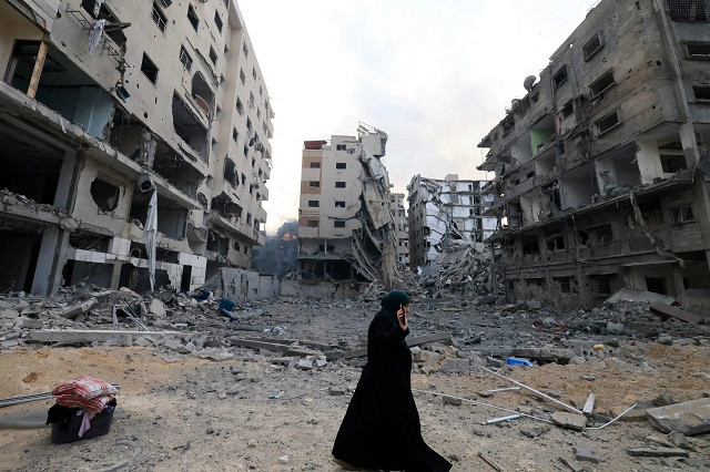 A Palestinian woman walks through a ravaged street following Israeli airstrikes on Gaza City. PHOTO AFP