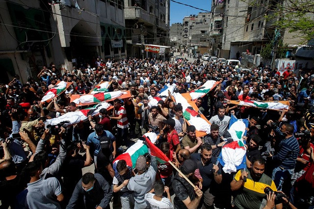 Mourners carry the bodies of Palestinians, including members of Abu Hatab family, who were killed amid a flare-up of Israeli-Palestinian violence, during their funeral at the Beach refugee camp, in Gaza City May 15, 2021. PHOTO: REUTERS