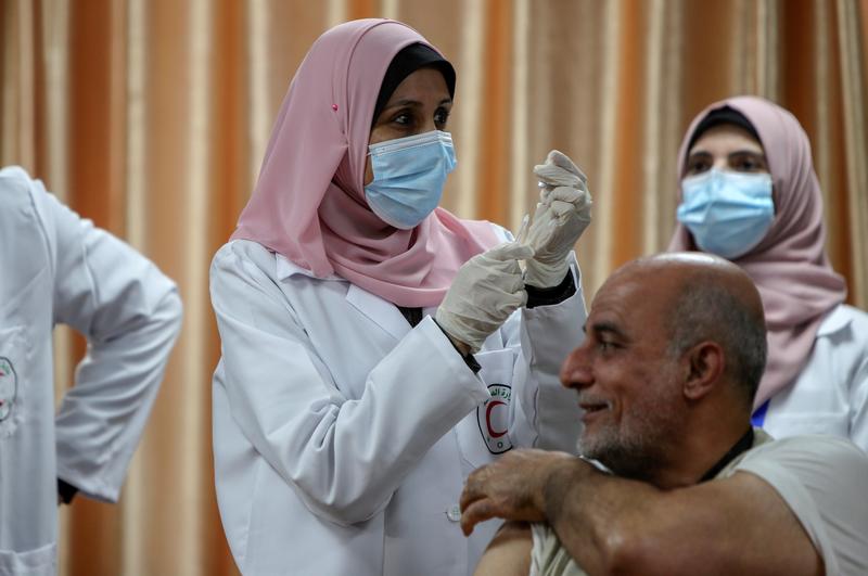 a health worker prepares to vaccinate former palestinian health minister jawad tibi against the coronavirus disease covid 19 vaccine in gaza city february 22 2021 photo reuters