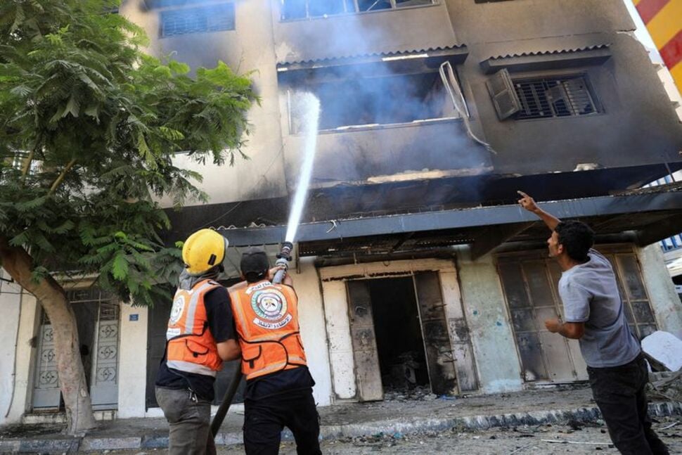 members of the civil defence work to extinguish fire in gaza city reuters