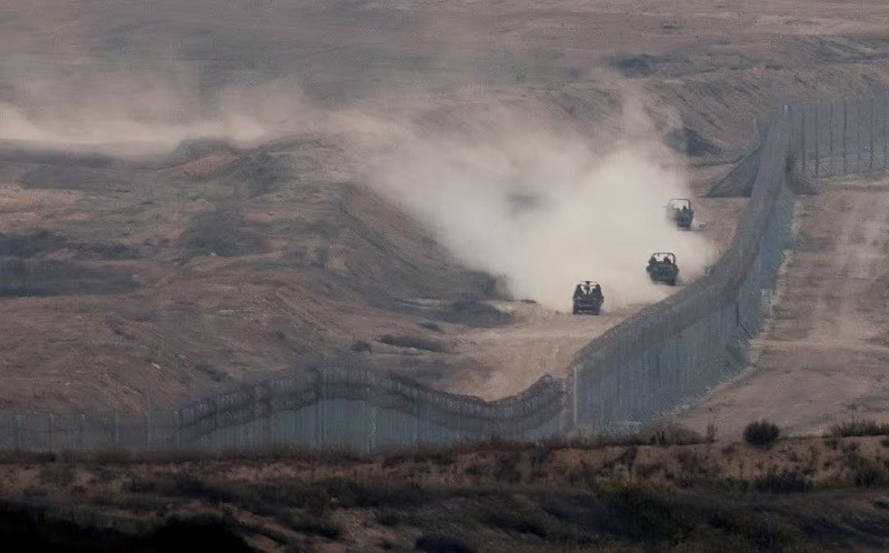 military vehicles manoeuvre next to a fence as seen from the israeli side of the border with gaza november 5 2023 photo reuters