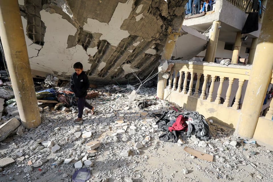 a palestinian boy walks at the site of an israeli strike on a school sheltering displaced people amid the israel hamas conflict in gaza city on november 27 2024 photo reuters