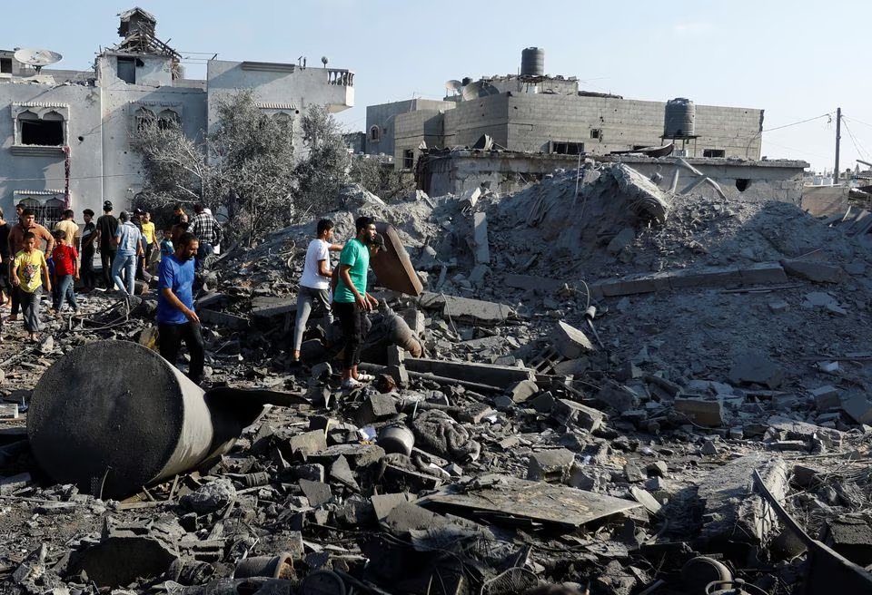 Palestinians search for casualties under the rubble in the aftermath of Israeli strikes, in Khan Younis in the southern Gaza Strip, October 14, 2023. PHOTO: REUTERS