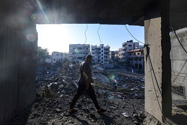 A resident of Gaza walks through the rubble of his neighbourhood following brutal Israeli airstikes. PHOTO: AFP