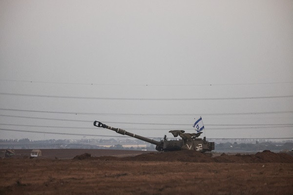 An Israeli flag flutters from a self-propelled howitzer near Israel's border with the Gaza Strip. PHOTO: Reuters