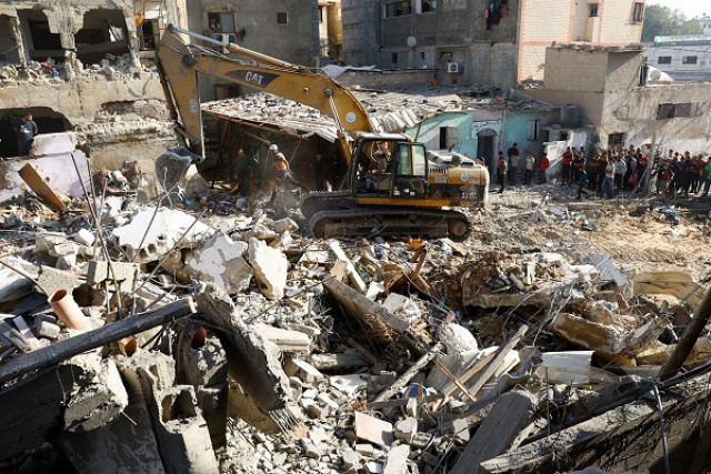 palestinians gather at the site of israeli strikes on a residential building photo reuters palestinians gather at the site of israeli strikes on a residential building photo reuters