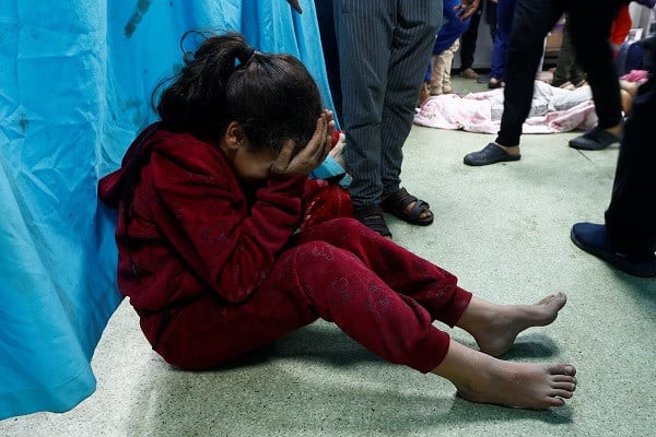 A wounded Palestinian child sits on the floor of Nasser hospital following Israeli strikes. PHOTO: Reuters