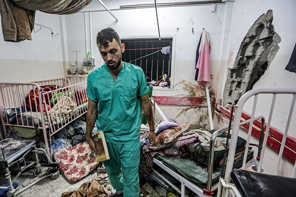 a medic inspects the damage in a room following israeli bombardment at nasser hospital in khan yunis in the southern gaza strip photo afp