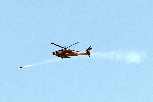 an israeli air force attack helicopter fires a missile while flying over the northern gaza strip photo afp
