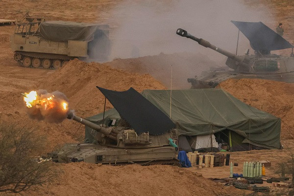 An Israeli army self-propelled artillery howitzer fires rounds from a position circuitously a limit with a Gaza Strip in southern Israel. PHOTO: AFP