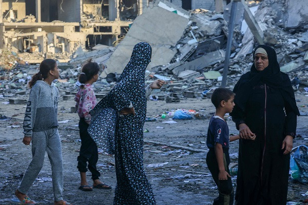 a family walks through the rubble of their neighbourhood following brutal israeli airstikes photo afp