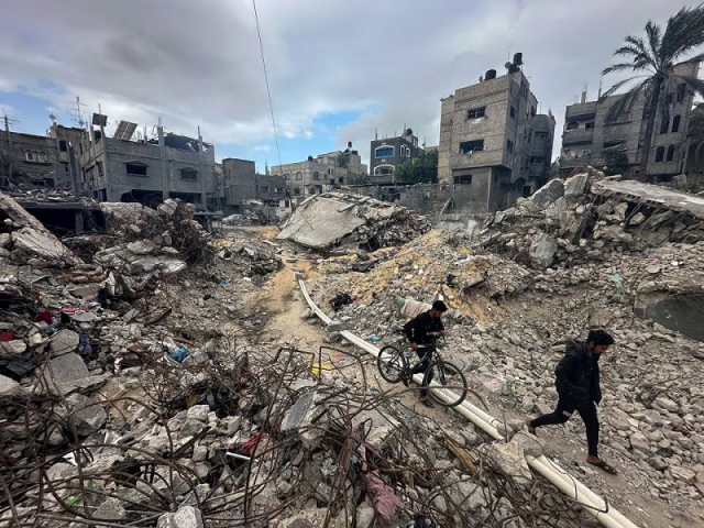 palestinians walk among the rubble at khan younis refugee camp in the southern gaza strip november 27 2023 photo reuters