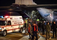 rescuers and soldiers stand near a c130 hercules military aircraft and an ambulance upon arrival of wounded palestinian from the gaza strip at tunis carthage airport on december 3 photo afp