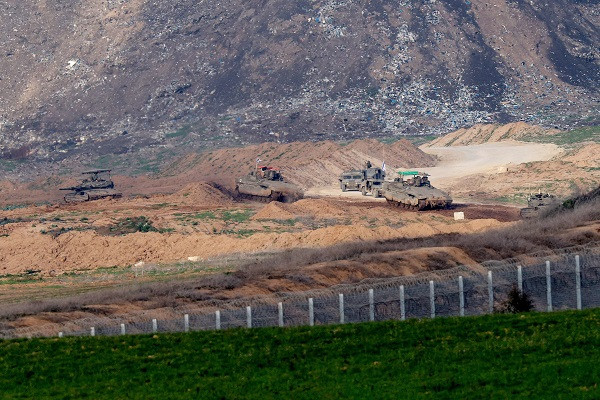 A picture taken from southern Israel on the border with the Gaza Strip shows shows Israeli army vehicles driving on a road in Gaza. PHOTO: AFP
