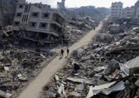 palestinians walk past destroyed houses photo reuters
