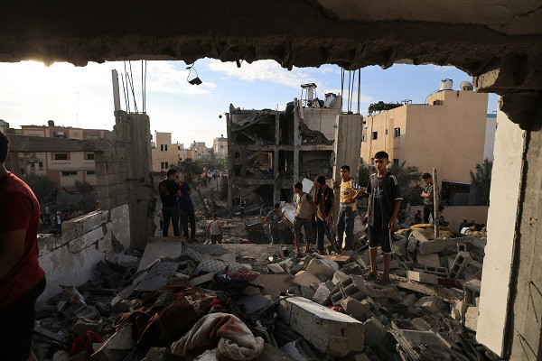 Palestinians search through the rubble of a building after an Israeli strike in Khan Yunis in the southern Gaza Strip. PHOTO: AFP
