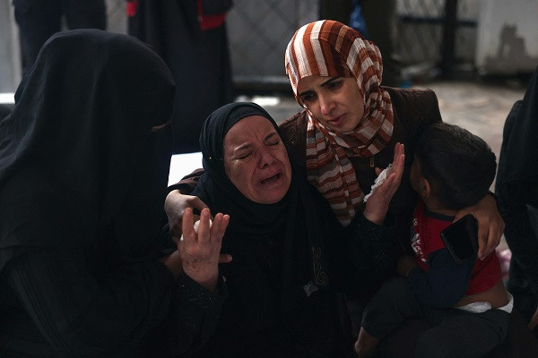 People mourn by the bodies of relatives killed in Israeli bombardment in Rafah in the southern Gaza Strip. PHOTO: AFP