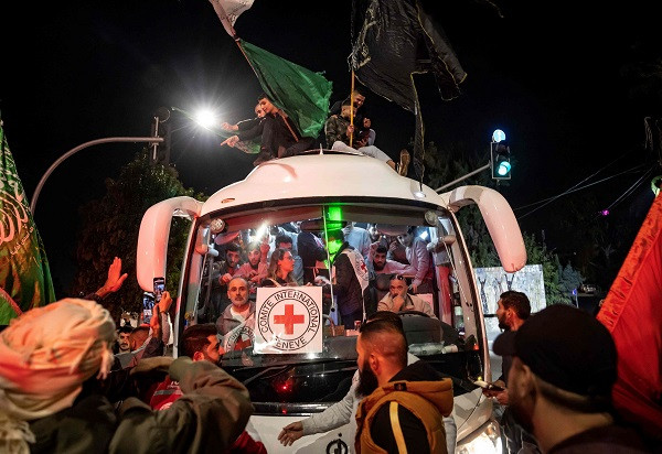 A crowd surrounds a Red Cross bus carrying Palestinian prisoners released from Israeli jails. PHOTO: AFP