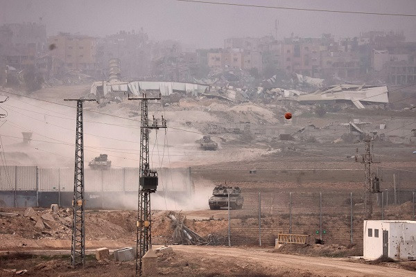 A picture taken from southern Israel near the border with the Gaza Strip shows Israeli armoured vehicles returning from the Palestinian territory. PHOTO: AFP