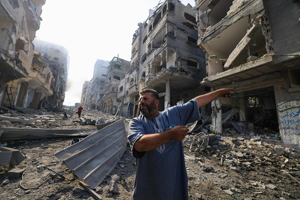 A Palestinian man points at destruction as people inspect the damage following overnight Israeli airstrikes in the Gaza Strip's Jabalia refugee camp. PHOTO:AFP