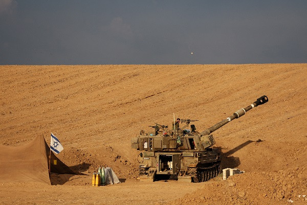 An Israeli soldier shades his eyes from the sun as he stands on a self-propelled howitzer near Israel's border with the Gaza Strip. PHOTO: Reuters