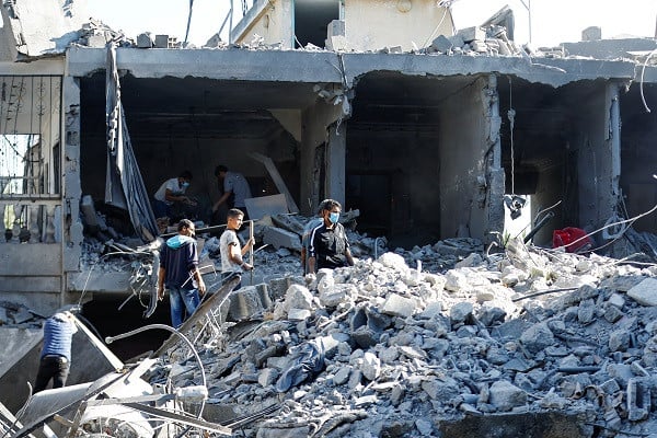 Palestinians search for casualties under the rubble in the aftermath of Israeli strikes. PHOTO: Reuters