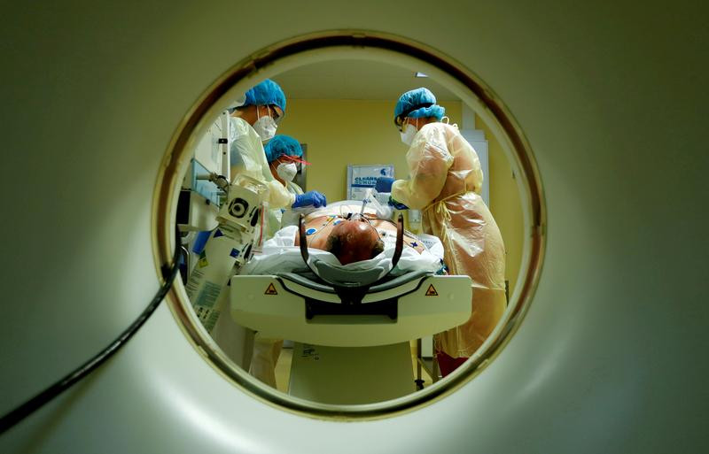 members of the medical staff in protective suits treat a patient suffering from the coronavirus disease covid 19 with a computer tomograph in the intensive care unit icu at havelhoehe community hospital in berlin germany photo reuters