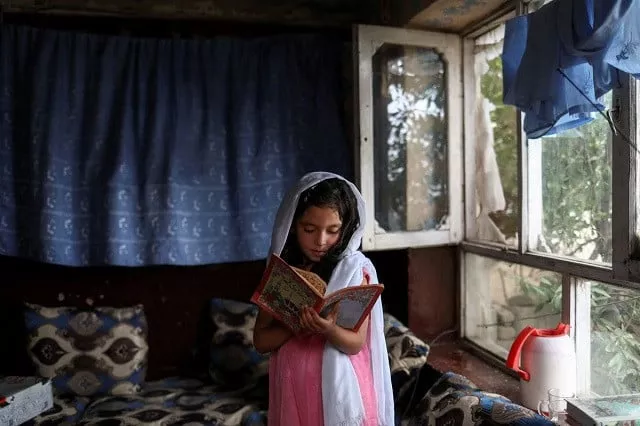 an afghan girl reads a book inside her home in kabul afghanistan june 13 2022 photo reuters