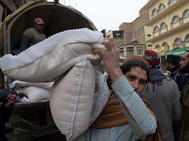a local resident carries wheat sacks photo afp