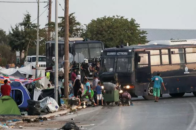 police block an area where refugees and migrants from the destroyed moria camp are sheltered during an operation to move them in a new temporary camp on the island of lesbos greece september 17 2020 photo reuters police block an area where refugees and migrants from the destroyed moria camp are sheltered during an operation to move them in a new temporary camp on the island of lesbos greece september 17 2020 photo reuters