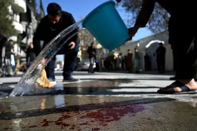 residents wash the road after the kabul ambush photo afp residents wash the road after the kabul ambush photo afp