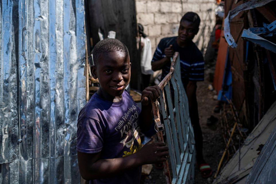 boys working at a metal recycler carry metal scavenged from houses destroyed in a 7 2 magnitude quake in les cayes haiti august 21 2021 photo reuters