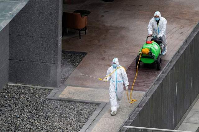 workers in protective suit spray disinfectant at a community during the lockdown to curb the spread of the coronavirus disease covid 19 in shanghai china april 5 2022 reuters
