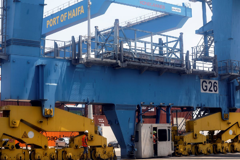 port workers wait for trucks to arrive and take containers from cargo ships while it is docked at the port of haifa israel august 8 2021 photo reuters