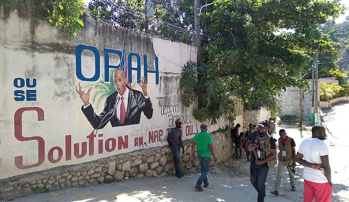 people walk past a wall with a mural depicting haiti s president jovenel moise after he was shot dead by unidentified attackers in his private residence in port au prince haiti july 7 2021 photo reuters