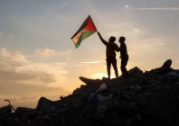 a boy runs with a palestinian flag atop a mound of rubble at a camp in bureij central gaza strip on friday photo afp