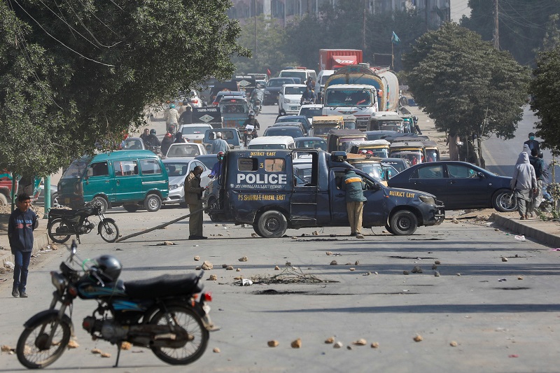 a police vehicle is parked on a road covered with stones thrown by protesters following the killings of hazara coal miners in karachi pakistan january 7 2021 photo reuters